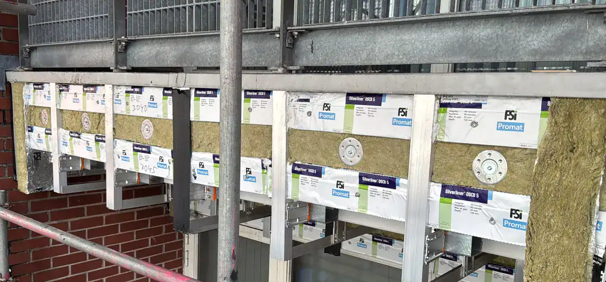 Exposed cavity barriers and façade support framing from the earlier site archive